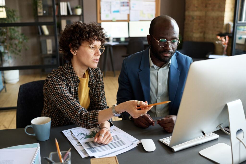 A male and female professional looks like Apply computer screen in office